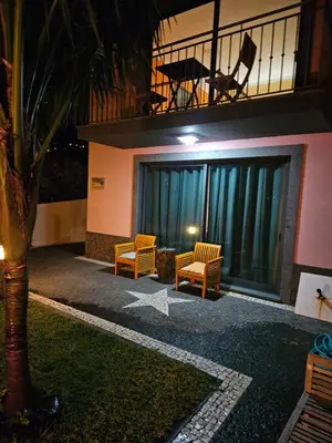 a building with two chairs and a star on the ground at Casa da Palmeira in Machico