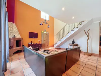 a living room with orange walls and a staircase at Casa da Palmeira in Machico