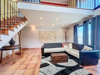 a living room with a blue couch and a staircase at Casa da Palmeira in Machico