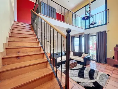 a living room with wooden stairs and a couch at Casa da Palmeira in Machico