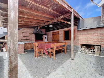 an outdoor patio with a table and a fireplace at Casa da Palmeira in Machico