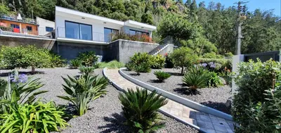 a house with a garden with plants in front of it at Casa Avós & Netas, Fantastic View, Near the Nature! in Arco da Calheta