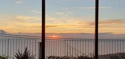 a view of the sunset from behind a fence at Casa Avós & Netas, Fantastic View, Near the Nature! in Arco da Calheta