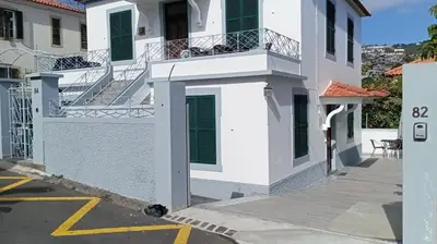 a white building with stairs and a balcony at Bus Stop House 82 in Funchal