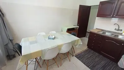 a kitchen with a table with chairs and a sink at Bus Stop House 82 in Funchal