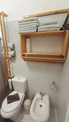 a bathroom with a toilet and a sink and towels at Bus Stop House 82 in Funchal