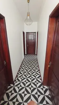 a hallway with a black and white tiled floor at Bus Stop House 82 in Funchal