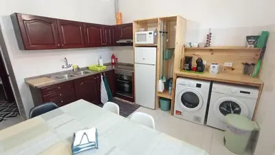 a kitchen with a sink and a washing machine at Bus Stop House 82 in Funchal