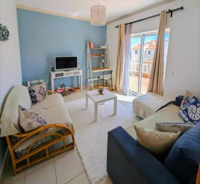a bedroom with a large bed and a balcony at Apartamento Sagres Sunset in Sagres