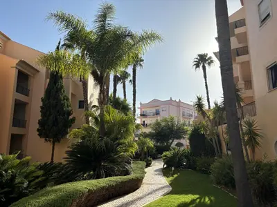 a garden with palm trees and a walkway at Seaview apartment Estrela da Luz Praia da Luz in Luz