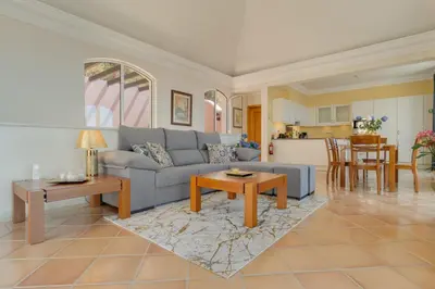 a living room with a blue couch and a table at Villa Eve Palheiro Village by Holiday Rental Madeira in Funchal