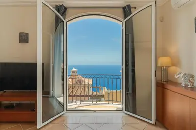 a sliding glass door with a view of the ocean at Villa Eve Palheiro Village by Holiday Rental Madeira in Funchal