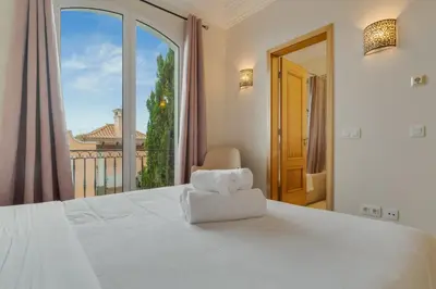 a bedroom with a large white bed and a large window at Villa Eve Palheiro Village by Holiday Rental Madeira in Funchal