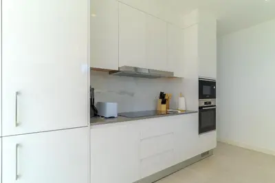 a white kitchen with white cabinets and appliances at Luxury Diamond House by Holiday Rental Madeira in Funchal