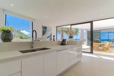 a kitchen with white cabinets and a view of the ocean at Luxury Diamond House by Holiday Rental Madeira in Funchal