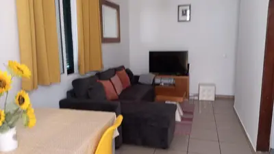 a living room with a couch and a tv at Jose's cozy little home in Funchal