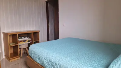 a bedroom with a blue bed and a wooden cabinet at Jose's cozy little home in Funchal