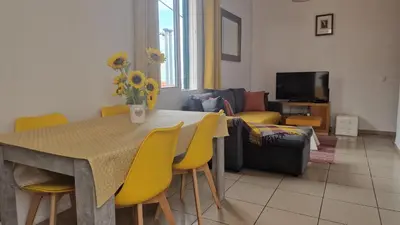 a living room with a table and yellow chairs at Jose's cozy little home in Funchal