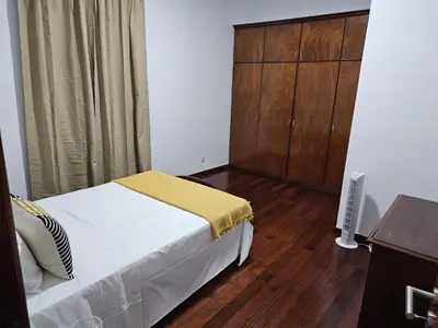 a bedroom with a bed and a cabinet and wooden floors at The View in Santa Cruz
