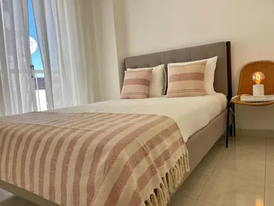 a bedroom with a bed with a large window at Casa da Aldeia in Bensafrim