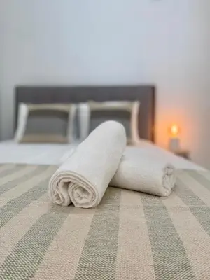 a rolled up towel sitting on a bed at Casa da Aldeia in Bensafrim