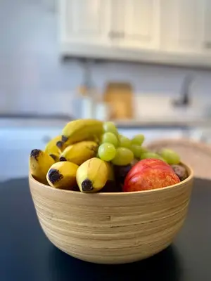a wooden bowl of fruit on a table at Casa da Aldeia in Bensafrim