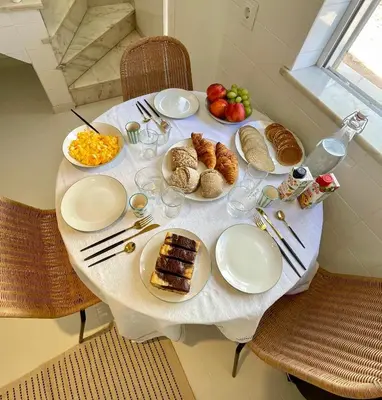 a white table with plates of food on it at Casa da Aldeia in Bensafrim