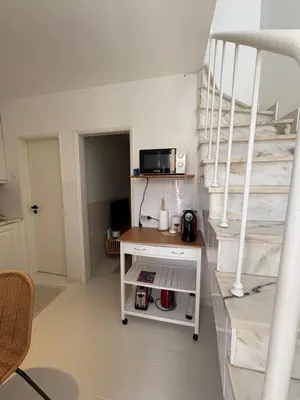 a room with a staircase and a table with a microwave at Casa da Aldeia in Bensafrim