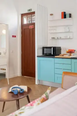 a kitchen with blue cabinets and a table in a room at Bela de Santiago I by An Island Apart in Funchal