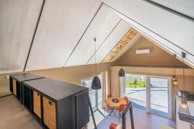 an attic living room with a tv and a table at Doca Seca & Casca de Uva in Porto Moniz