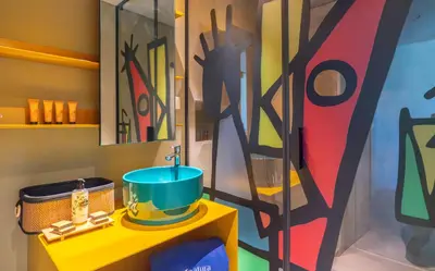a bathroom with a sink and a large painting on the wall at Doca Seca & Casca de Uva in Porto Moniz