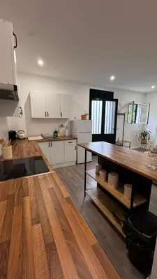 a kitchen with white cabinets and a wooden table at Revived in Porto da Cruz
