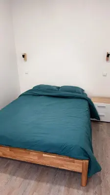 a bed with a blue comforter in a bedroom at Revived in Porto da Cruz