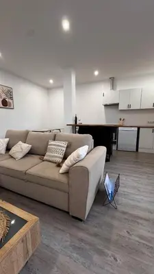 a living room with a couch and a kitchen at Revived in Porto da Cruz