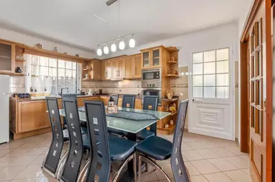 a kitchen with a glass table and chairs at Linda Paisagem in Calheta