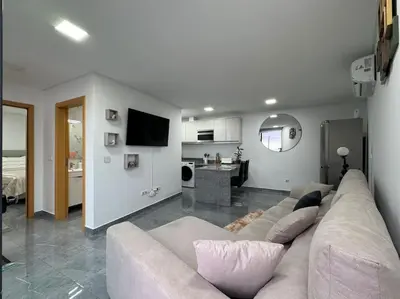 a living room with a couch and a kitchen at Villa Castanho II in Calheta