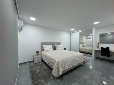 a white bedroom with a bed and a mirror at Villa Castanho II in Calheta