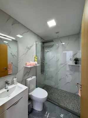 a bathroom with a shower and a toilet and a sink at Villa Castanho II in Calheta