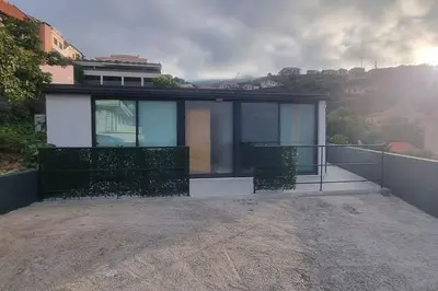 a house with glass doors on a balcony at Villa Castanho II in Calheta
