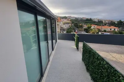 a balcony of a building with glass windows at Villa Castanho II in Calheta