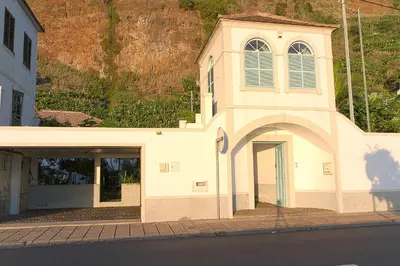 a building with a tower with a door and a garage at Casa da Madalena do Mar in Madalena do Mar