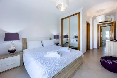 a bedroom with a large white bed with a mirror at Boa Vista - Fairview Island in Lagos