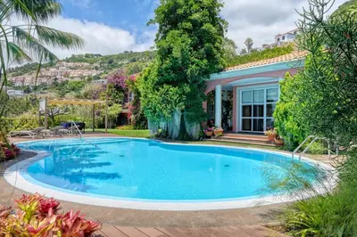 a swimming pool in front of a house at Casa das Bromélias, a Home in Madeira in Funchal