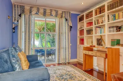 a blue living room with a desk and a window at Casa das Bromélias, a Home in Madeira in Funchal