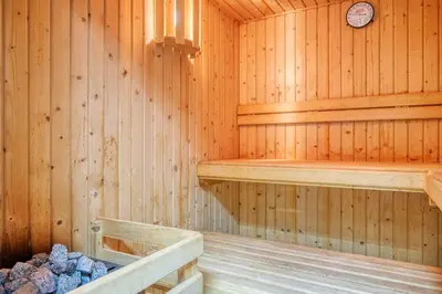 a wooden sauna with two shelves and a clock at Casa das Bromélias, a Home in Madeira in Funchal