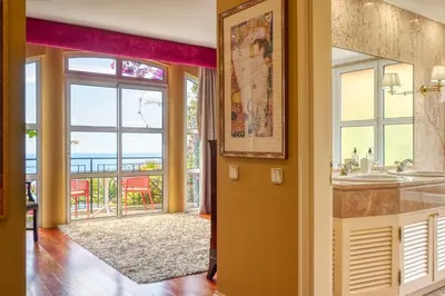 a bathroom with two sinks and a view of the ocean at Casa das Bromélias, a Home in Madeira in Funchal