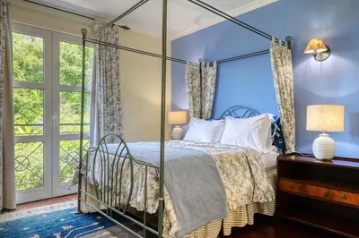a bedroom with a canopy bed and a window at Casa das Bromélias, a Home in Madeira in Funchal