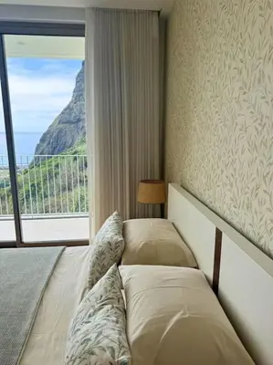 a bedroom with two beds and a large window at Cardais Paradise View in São Vicente