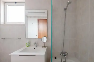 a bathroom with a shower and a sink and a mirror at Madeira Sunny Penthouse in Funchal