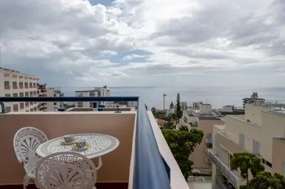 a balcony with a table and a view of the ocean at Madeira Sunny Penthouse in Funchal